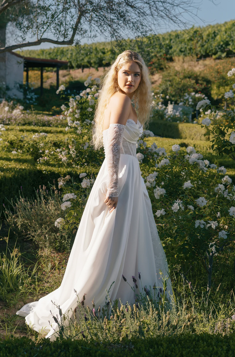 Bérénice - robe de mariée moderne avec haut corset sans bretelle en dentelle non perlé avec jupe de satin luxueuse et fente en dentelle, gants amovibles Bérénice - robe de mariée moderne avec haut corset sans bretelle en dentelle non perlé avec jupe de satin luxueuse et fente en dentelle, gants amovibles