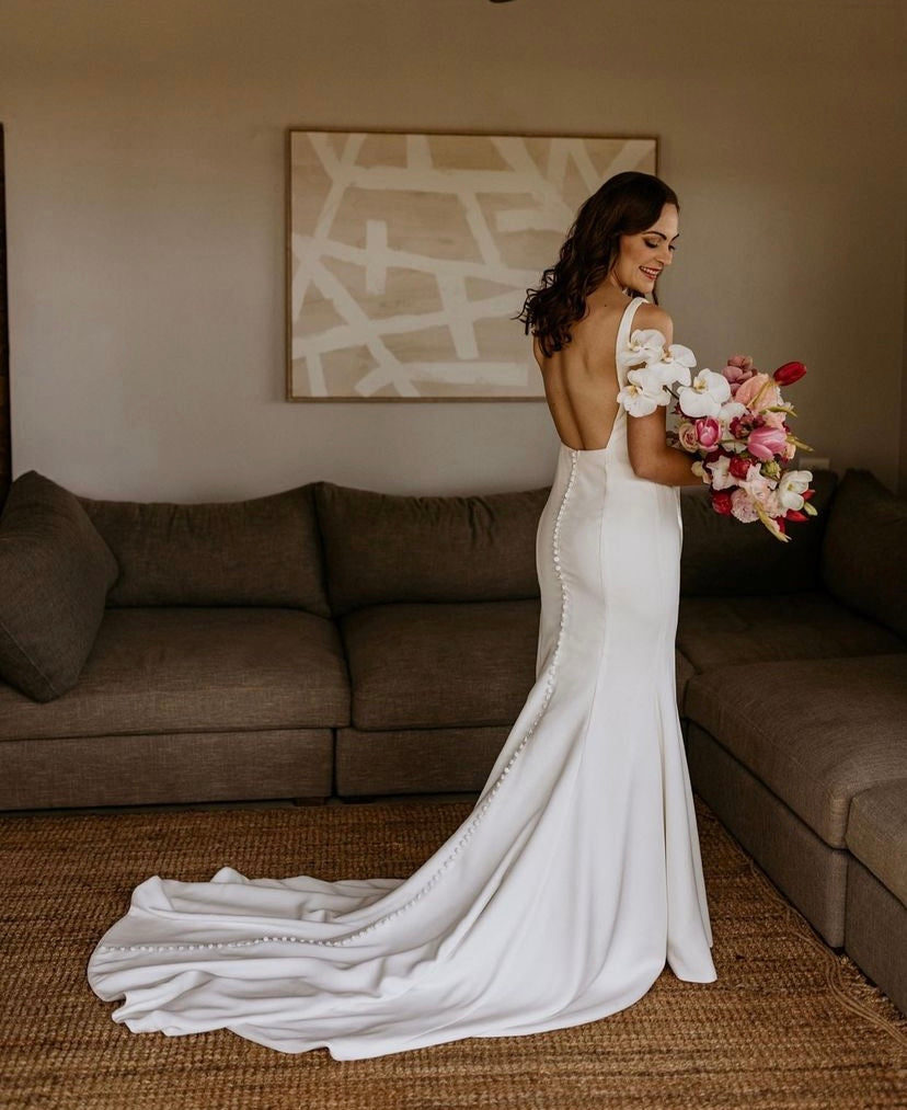 Carmen - robe de mariée moderne ajustée et épurée à encolure carré et ouvertures transparentes sur les côtés Carmen - robe de mariée moderne ajustée et épurée à encolure carré et ouvertures transparentes sur les côtés