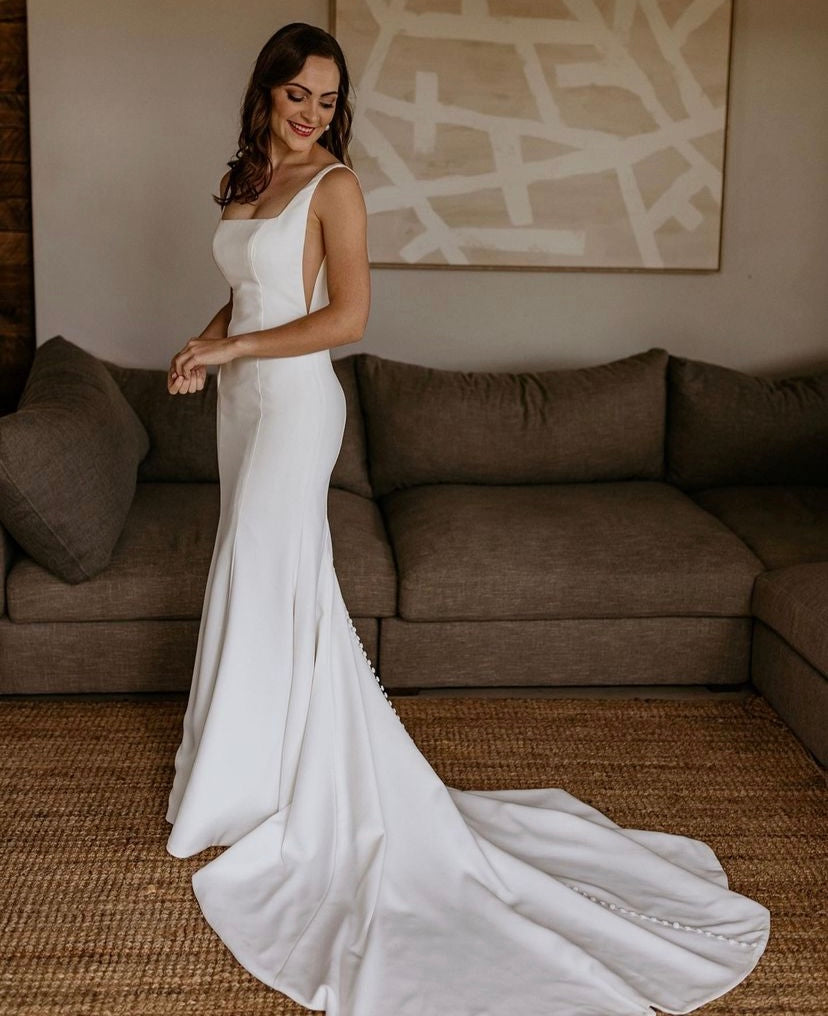 Carmen - robe de mariée moderne ajustée et épurée à encolure carré et ouvertures transparentes sur les côtés Carmen - robe de mariée moderne ajustée et épurée à encolure carré et ouvertures transparentes sur les côtés