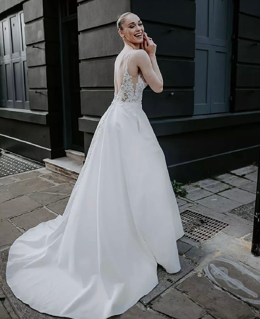 Ranger - robe de mariée classique à décolleté plongeant illusion en dentelle et jupe en satin mât avec poches Ranger - robe de mariée classique à décolleté plongeant illusion en dentelle et jupe en satin mât avec poches